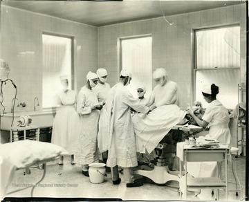 A group of doctors work on a patient in a hospital.