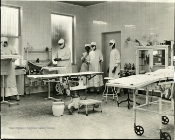 Doctors prep for surgery in a hospital operating room.