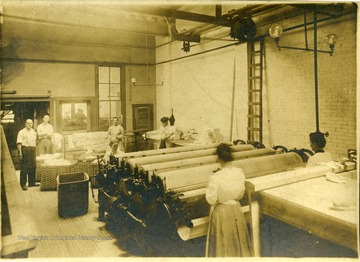 Women work with machinery inside the Empire Laundry Company.