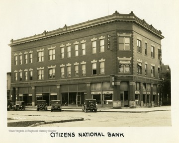 Several cars are parked in front of the two story brick Citizens National Bank building in Elkins, West Virginia.