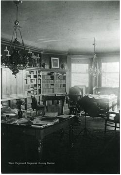 Well decorated room with a bookshelf, globe, and desks with chairs set up.