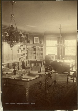 Well decorated room with a bookshelf, globe, and desks with chairs set up. 