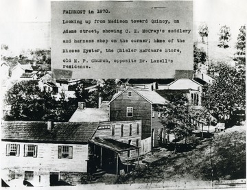 'Looking up Madison toward Quincy, on Adams street, showing C. E. McCray's saddlery and harness shop on the corner; home of the Misses Eyster, the Chisler Hardware Store, old M. P. Church, opposite Dr. Lazell's residence.'