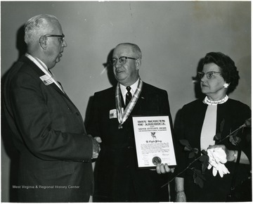 L. Clyde Riley shaking hands with a man upon receiving the Boy Scouts of America Silver Antelope Award.