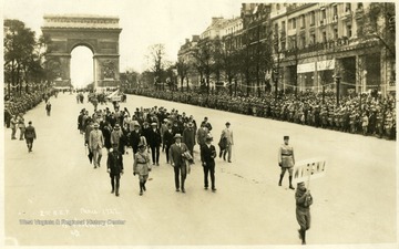 2nd A. E. F. in Paris, 1927.  From undated Charleston Daily News clipping, 'This photograph of the Legion parade taken in the French Capitol during the convention last summer has just been received by Boyd B. Stutler, secretary of the delegation.   It shows the West Virginia delegation just after it had passed under the Arch de Triomphe where each man placed a flower on the grave of the Unknown soldier.  Colonel Lewis Johnson, of Clarksburg, chairman of the delegation is marching in the head with his overcoat on his arm.  To his left is Mr. Stutler, and immediately behind Mr. Stutler, wearing the big hat is C. M. (Casey) Jon [sic] In the foreground is William Morris Stutler, young son of Mr. Stutler, carrying the state's banner.  Among the 21 Charlestonians in the group are Harry Kessell, Ben Bioarsky, John Crockett, and Mrs. Cora B. Haynes.'