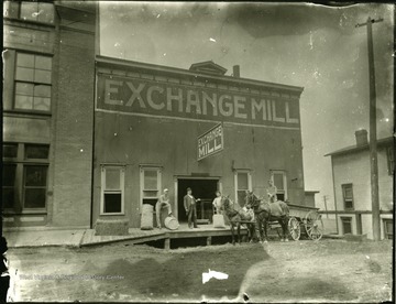 Three men and another with a horse drawn carriage in front of the Exchange Mill in Grafton, W. Va.