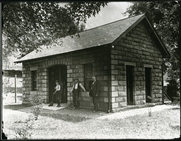 Two men and one boy standing in front of a tool shed at the National Cemetery in Grafton, W. Va.