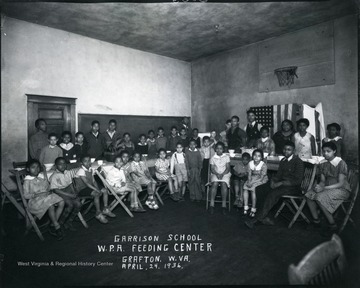 Chilren sit and stand in the W. P. A. feeding center.