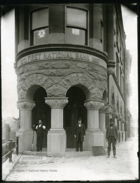 Three men standing in the entrance of the First National Bank in Grafton, W. Va.