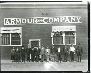 Group portrait of employees standing outside the Armour and Company Building in Grafton, West Virginia.
