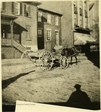 George Timmons driving his horse and wagon on a street in Grafton, W. Va.