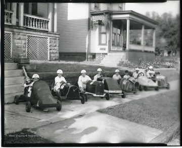 Group portrait of go cart racers in Grafton, W. Va. The race winner (far left) holds up his trophy.