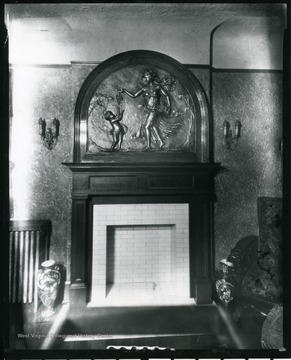 Ornate fireplace with large mantle piece with a woman giving a child grapes.  Grafton, W. Va.