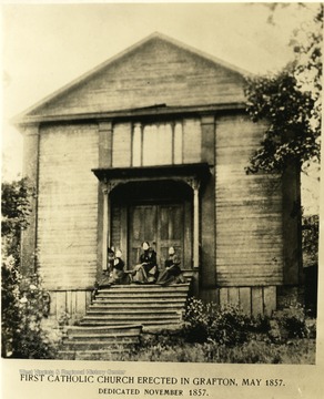 Three women seated on the steps of the wooden Catholic Church building in Grafton.  Church was completed in May 1857 and dedicated in November 1857.