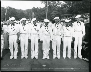 Men dressed up in their uniforms line up for a group picture.