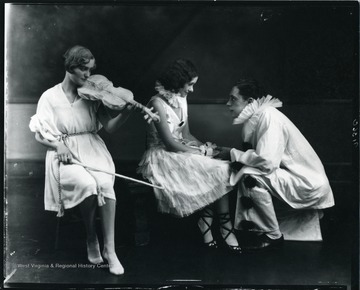 Three actors perform a scene from the play Prunella.