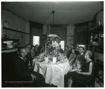 People seated around an elaborate dinner table.