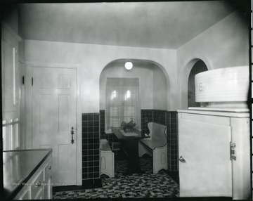 Nook off of the kitchen with a table and two benches for sitting.