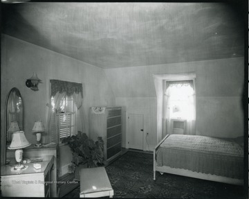 Bedroom with bed, dresser and vanity.