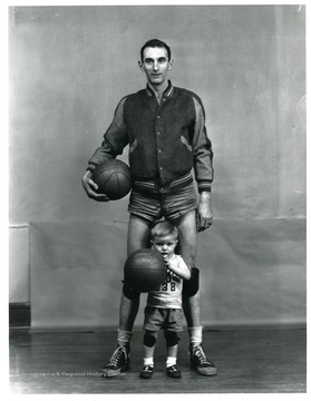 A big basketball player poses with a little basketball player.