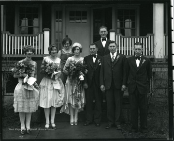 Bride and groom with the bridesmaids and the best men pose for a portrait.