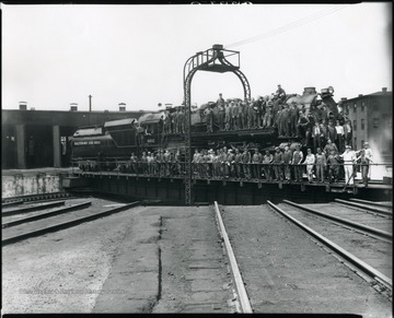B&O Crew standing on a train engine while it's on a roundhouse turntable in Grafton, W. Va.