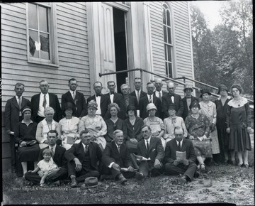 'Second Row, Left to Right, Fourth from Left: Margaret Leach Felton (Mrs. George C. Felton). First Row seated on ground, Left to Right: Tracey Felton holding unidentified boy; George C. Felton.'