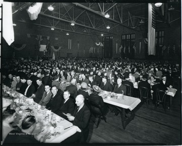 Large crowd of people seated for dinner in the Grafton High School gym.
