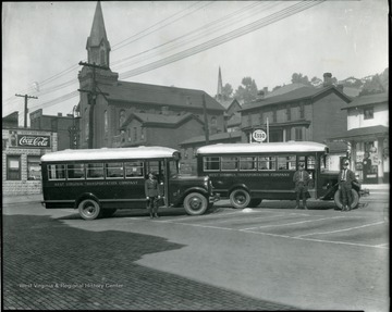 Two West Virginia Transportation Company buses.  Drivers are standing with the buses.  Mother's Day Shrine visible in the background in Grafton, W. Va.
