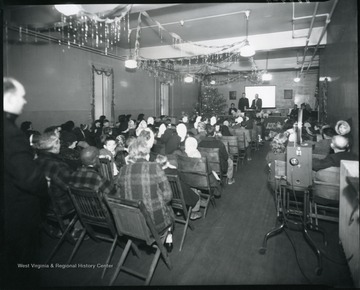 Group of people sitting at a Christmas program.  Toys are in the front of the room.  Grafton, W. Va.