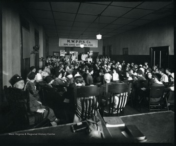 Crowd of women sitting for M.W.P.P.S. Co. Home Service Cooking School, Grafton, W. Va.