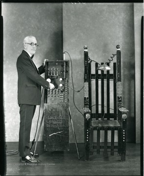 Man demonstrating an electric chair.