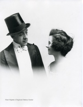 A woman is looking at a man who is wearing a top hat.
