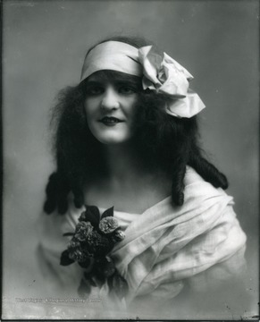 Portrait of a woman with roses pinned on her dress.