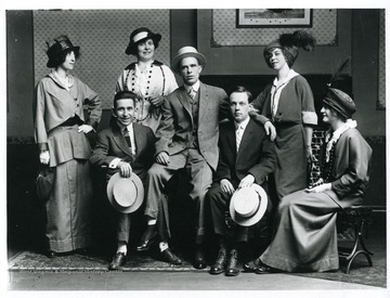 Four women and two male entertainers pose for a group portrait.