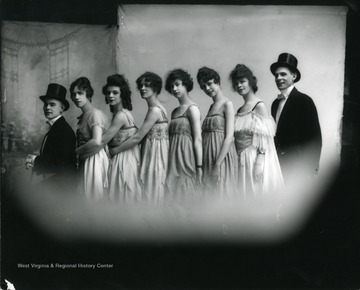 Six female entertainers are standing in between two male entertainers.