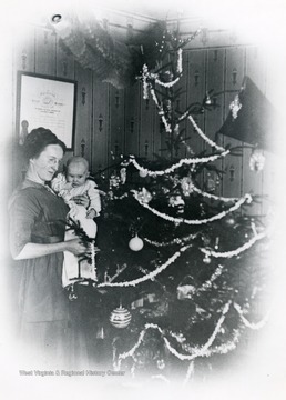 Olga Aegerter Holtkamp and baby place decorations on the Christmas tree.