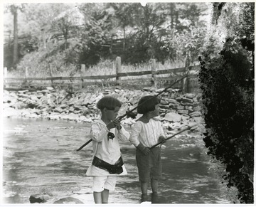 Two children are fishing in a creek in Helvetia, West Virginia.