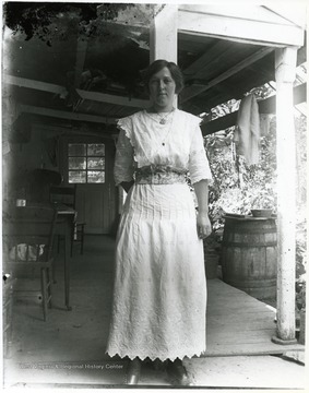 Younger woman standing alone on a porch, Helvetia, W. Va.