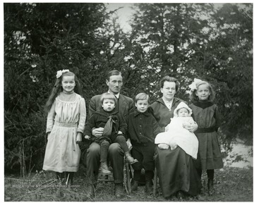 An unidentified family of seven seated outside for a portrait, Helvetia, West Virginia. 