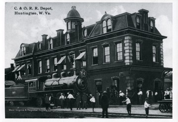 Postcard of a train engine and people outside of the C and O Depot in Huntington, West Virginia. See original for correspondence. (From postcard collection legacy system.)