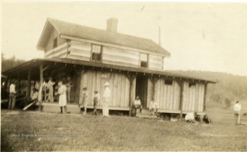 People outside a log building which served as the locker room at Spring Valley Country Club.