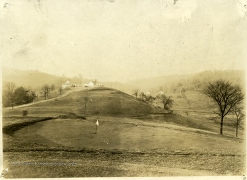 Large building on a hill overlooking the golf course.