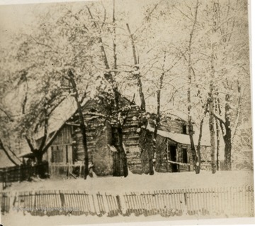 Log cabin behind some trees on a wintry day in Huntington, West Virginia.