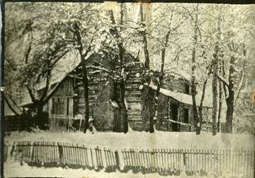 The Russell Home, a log cabin, at the south west corner of 5th Avenue and 11th Street in Huntington, West Virginia. Razed in 1900.  'Eliza Adams ran dairy.'