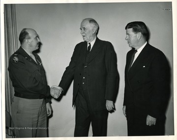 'March 22, 1947. On occasion of the citation of George S. Wallace for civilian service in World War II. Left to right: Colonel J.G. Hearne, George S. Wallace, and Mayor Douglas C. Tomkies.'