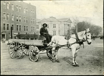 Dan Hill and his horse drawn wagon, the first taxi in Huntington.