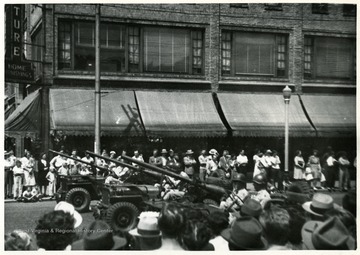 Soldiers driving armed vehicles in a parade, Huntington, W. Va.