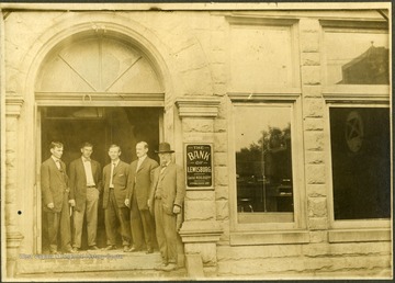 Five men stand in the entrance of the Bank of Lewisburg.