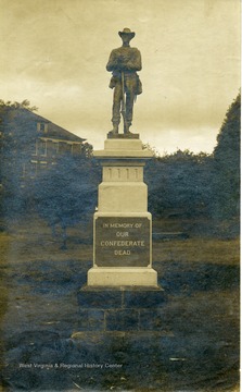 A close-up view of a Confederate Monument in Lewisburg, West Virginia. A Confederate Soldier is standing on top of a plaque that reads: "In Memory of Our Confederate Dead.'